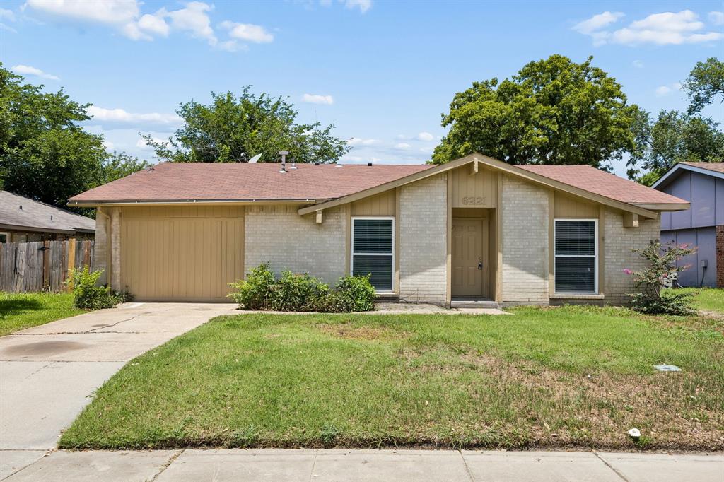 6221 Pine Street Rowlett, TX 75089 - Photo 1 of 12 Single-story residence featuring light-colored brick facade, a brown asphalt shingle roof, and an attached single-car garage with a matching brown door