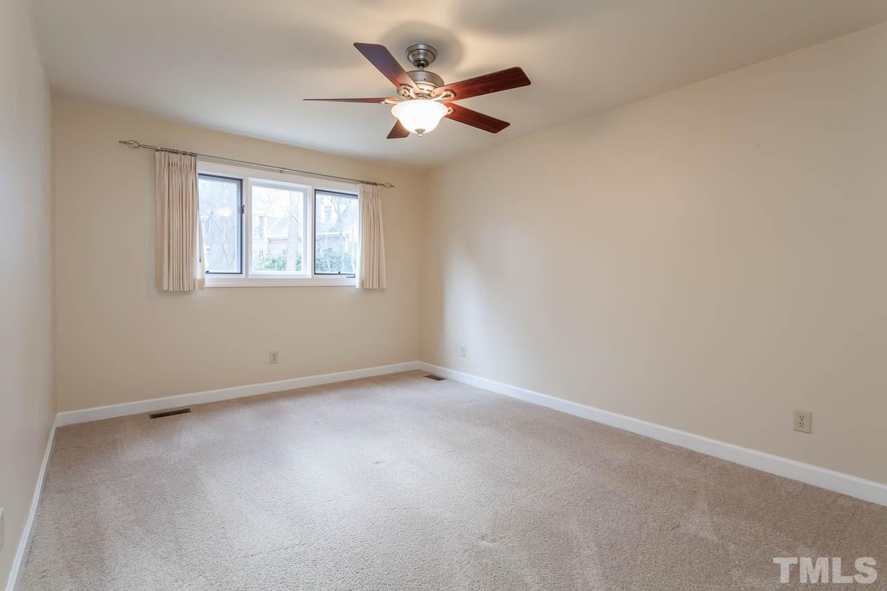 6909 Valley Ridge Court Raleigh, NC 27615 - Photo 20 of 25 an empty room with a ceiling fan and window