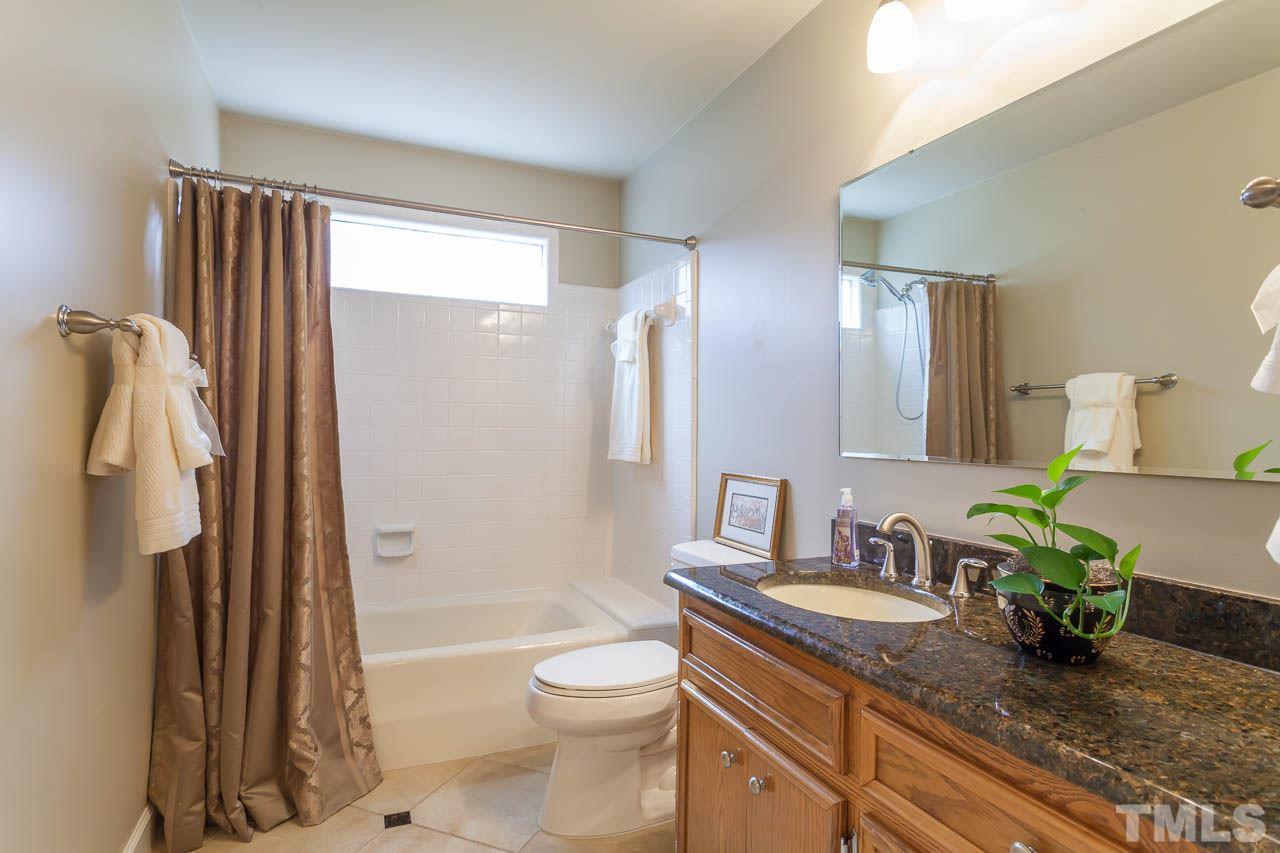 6909 Valley Ridge Court Raleigh, NC 27615 - Photo 21 of 25 a bathroom with a granite countertop sink toilet and shower