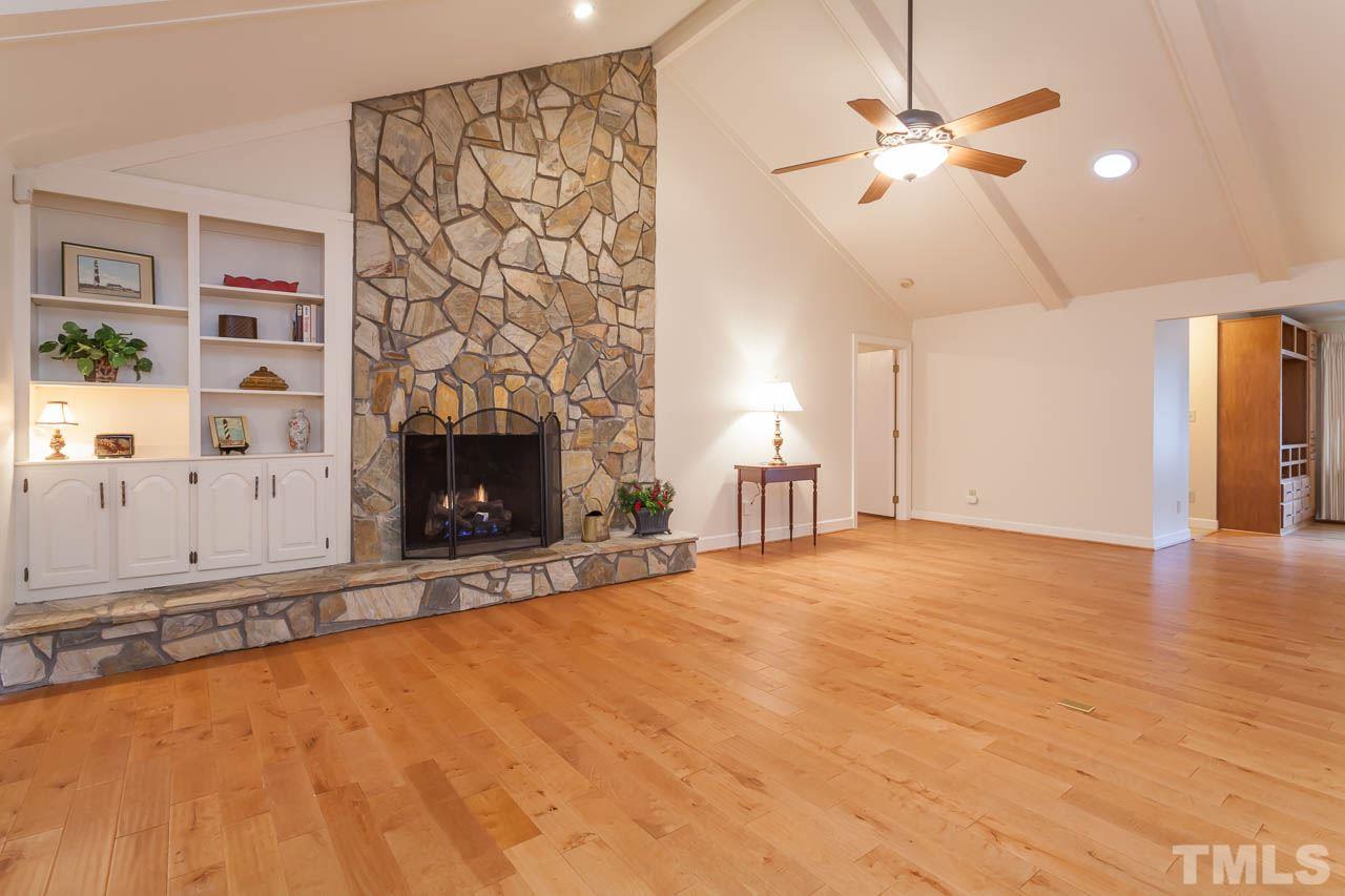 6909 Valley Ridge Court Raleigh, NC 27615 - Photo 4 of 25 a view of an empty room with chandelier fan and fire place