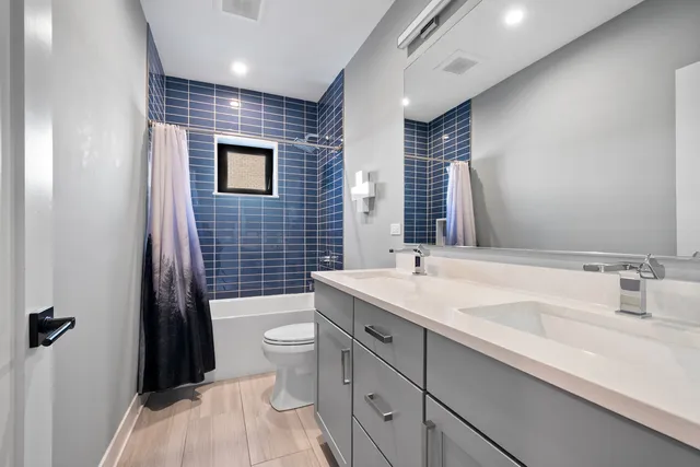 a bathroom with a sink a toilet a mirror and shower