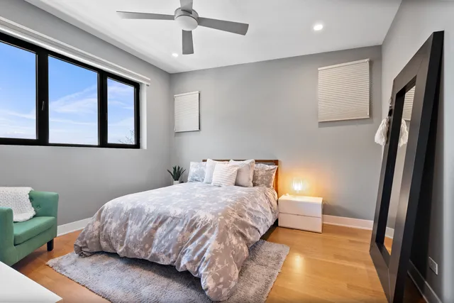a bedroom with a bed lamp and a large window