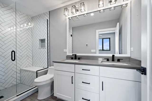 a bathroom with a granite countertop sink a toilet and a mirror