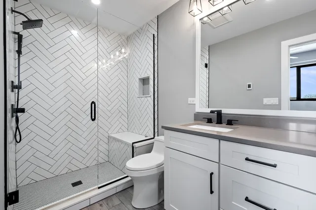 a bathroom with a sink a toilet and shower