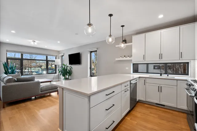 a large white kitchen with a large window a sink and a stove