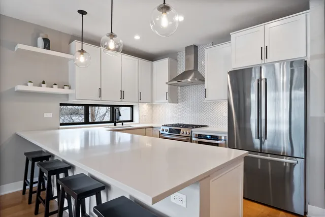 a kitchen with kitchen island a stove a refrigerator and a sink
