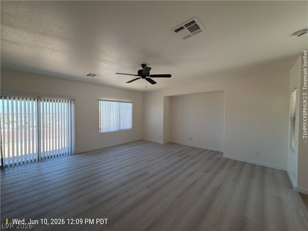 2388 Rue Bienville Way Henderson, NV 89044 - Photo 3 of 16 A versatile living space with light wood-look flooring and a ceiling fan awaits your personal touch.