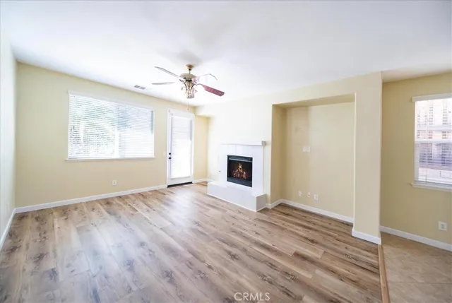 a view of a livingroom with wooden floor and a ceiling fan