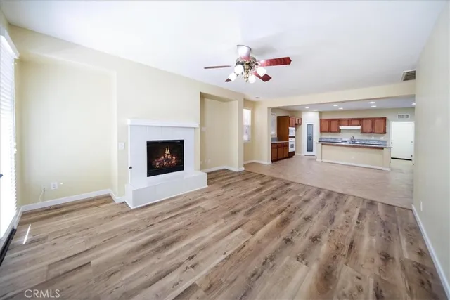 a view of a livingroom with wooden floor and a ceiling fan