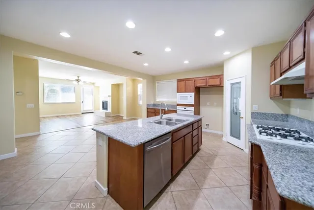 a kitchen with granite countertop cabinets stainless steel appliances and a counter space