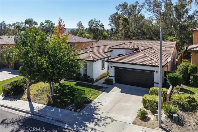 a front view of a house with a garden and plants