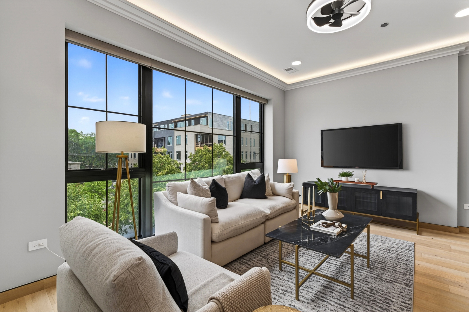 2024 West Irving Park Road, Unit 302 Chicago, IL 60618 - Photo 5 of 32 a living room with furniture a flat screen tv and a floor to ceiling window