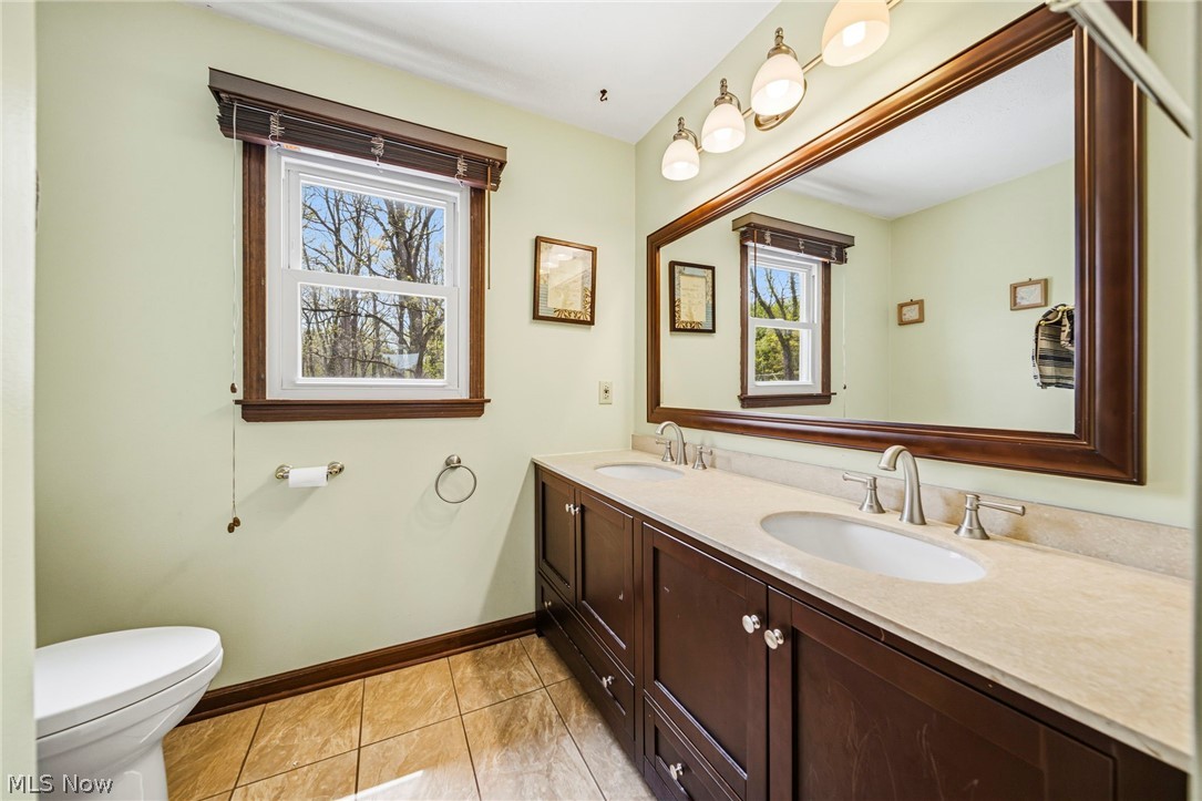10610 Ridgewater Drive Painesville, OH 44077 - Photo 17 of 23 Bathroom featuring a dual vanity with light-toned countertops, two undermount sinks, and brushed nickel faucets