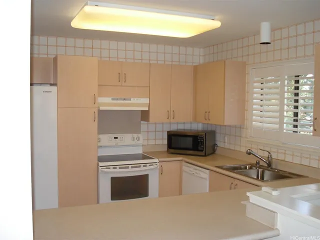 a kitchen with granite countertop a sink stainless steel appliances and cabinets