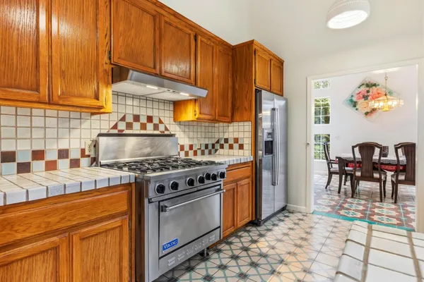 a kitchen with stainless steel appliances granite countertop a stove refrigerator and a sink