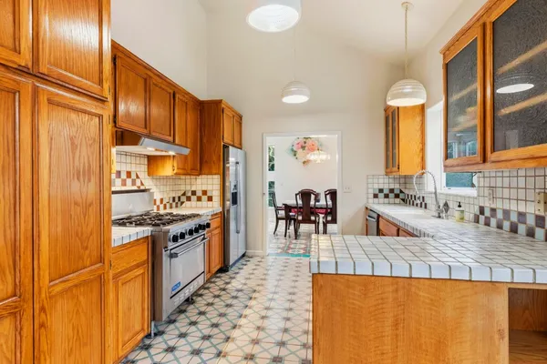 a kitchen with stainless steel appliances granite countertop a stove a sink and a refrigerator