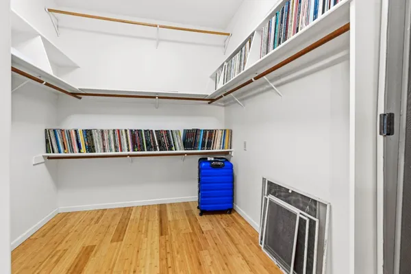 a view of walk in closet with clothes and shoes