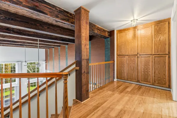 a view of a hallway with wooden floor and staircase