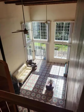 a view of a living room with furniture and floor to ceiling window