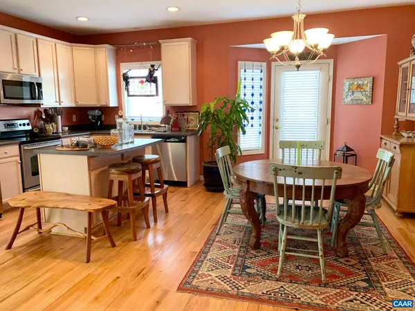 a view of a dining room with furniture a chandelier and wooden floor