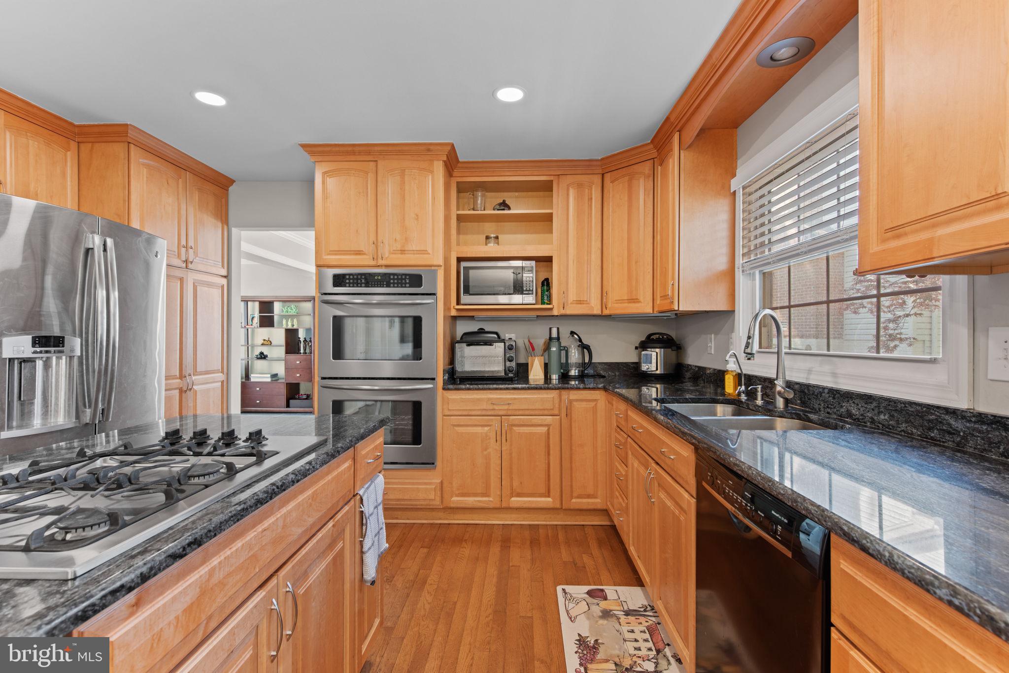 8104 Creekview Drive Springfield, VA 22153 - Photo 9 of 39 a kitchen with stainless steel appliances granite countertop a stove top oven a sink dishwasher a refrigerator and cabinets with wooden floor