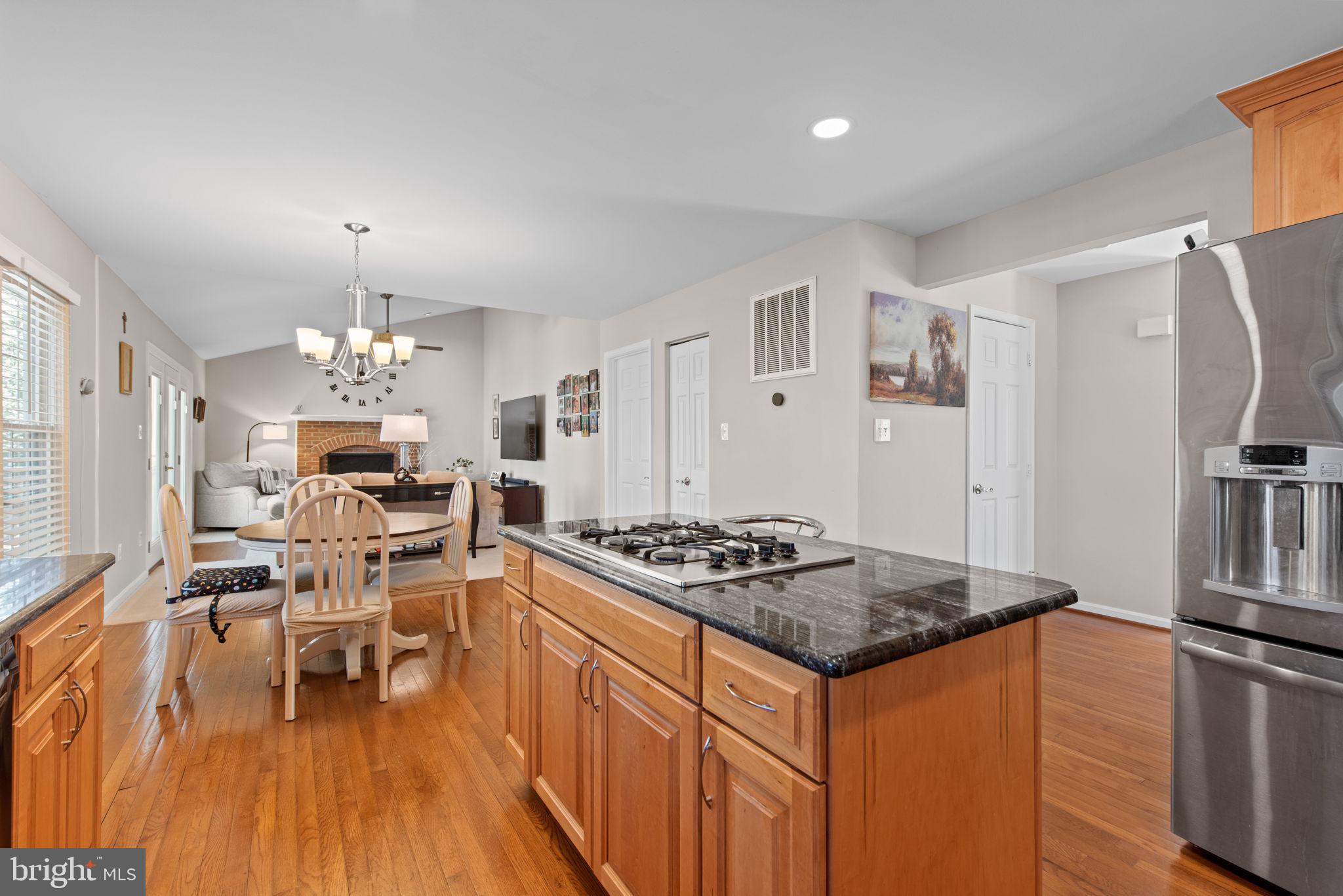 8104 Creekview Drive Springfield, VA 22153 - Photo 10 of 39 a kitchen with stainless steel appliances granite countertop a stove refrigerator and a dining table with wooden floor