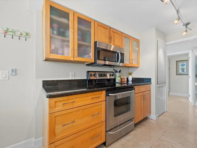 a kitchen with stainless steel appliances granite countertop a sink a stove and a refrigerator