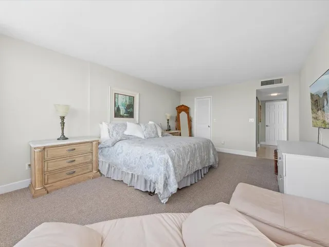 a bedroom with bed couch and window