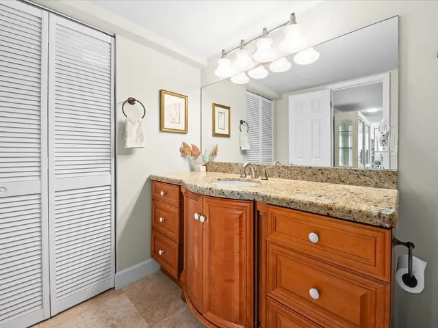 a bathroom with a granite countertop sink and a mirror