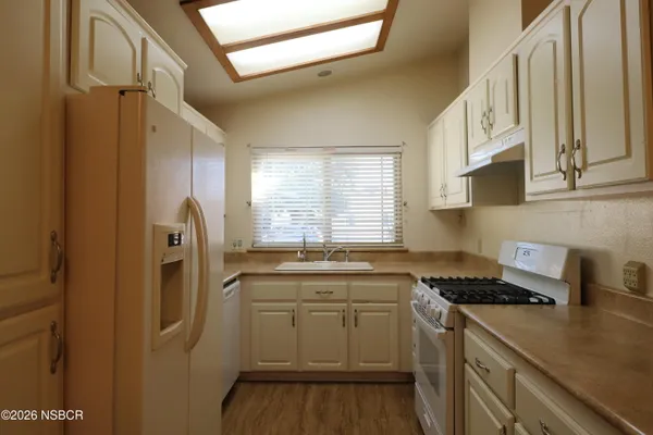 a kitchen with a sink a refrigerator and cabinets