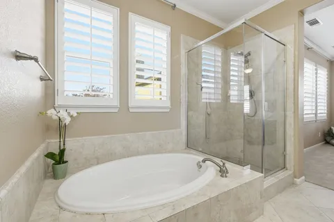 a white bath tub sitting next to a shower