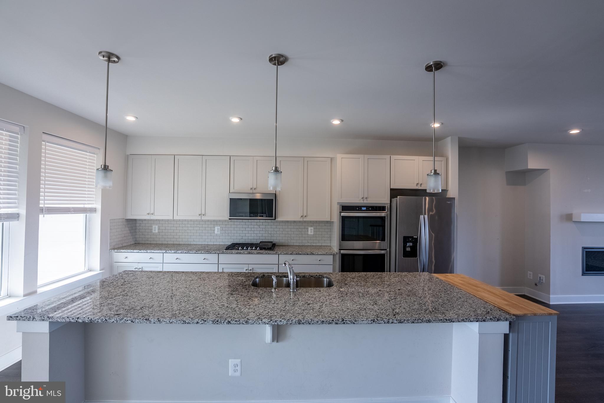 1622 Sandpiper Bay Loop Dumfries, VA 22026 - Photo 26 of 47 a kitchen with stainless steel appliances granite countertop a sink refrigerator and cabinets
