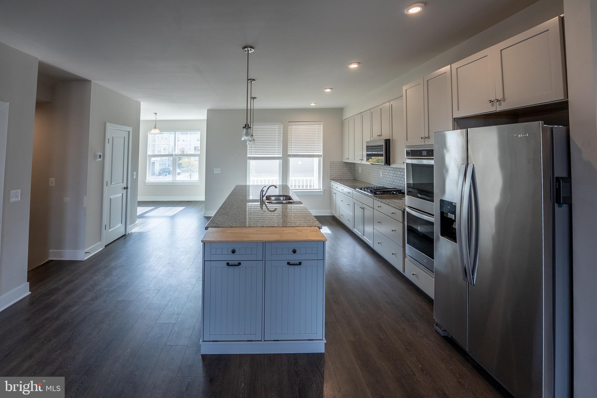 1622 Sandpiper Bay Loop Dumfries, VA 22026 - Photo 28 of 47 a kitchen with stainless steel appliances granite countertop a refrigerator a sink dishwasher a stove and white countertops with wooden floor