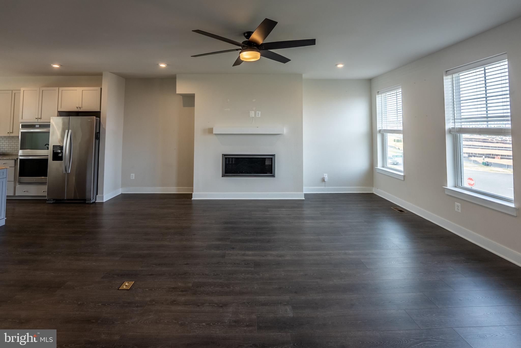 1622 Sandpiper Bay Loop Dumfries, VA 22026 - Photo 30 of 47 an empty room with wooden floor a ceiling fan and kitchen view