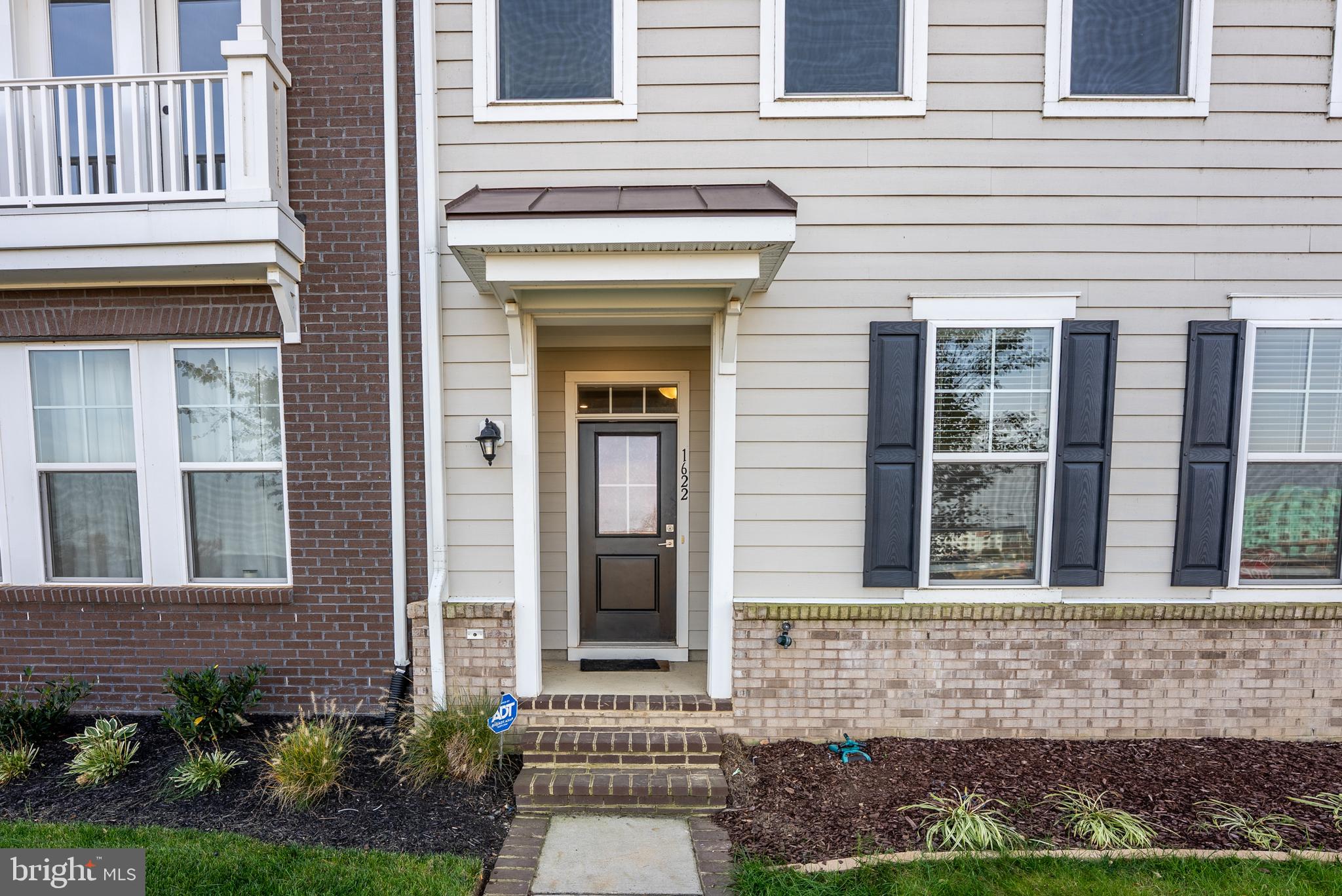 1622 Sandpiper Bay Loop Dumfries, VA 22026 - Photo 3 of 47 front view of a brick house with a yard
