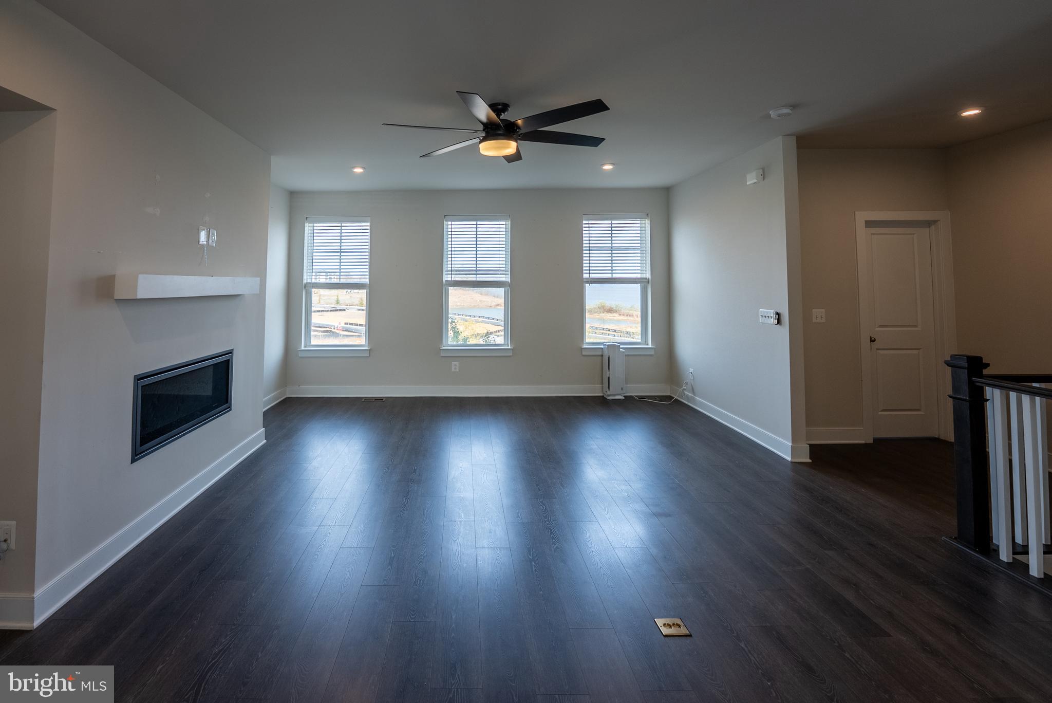 1622 Sandpiper Bay Loop Dumfries, VA 22026 - Photo 32 of 47 an empty room with wooden floor a fireplace and windows