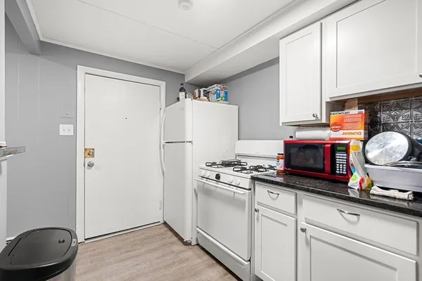 a kitchen with granite countertop a stove a refrigerator and a sink