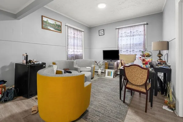 a living room with furniture a flat screen tv and a window