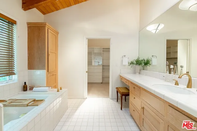 a spacious bathroom with a tub sink and mirror