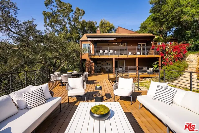 a view of a deck with couches table and chairs and potted plants