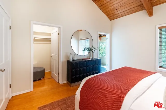 a bedroom with a bed mirror and a window