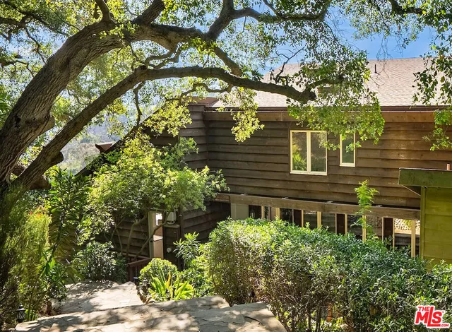 a front view of a house with a garden