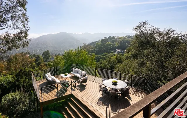 a view of a balcony with two chairs and a wooden fence