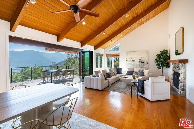a living room with fireplace furniture and a large window