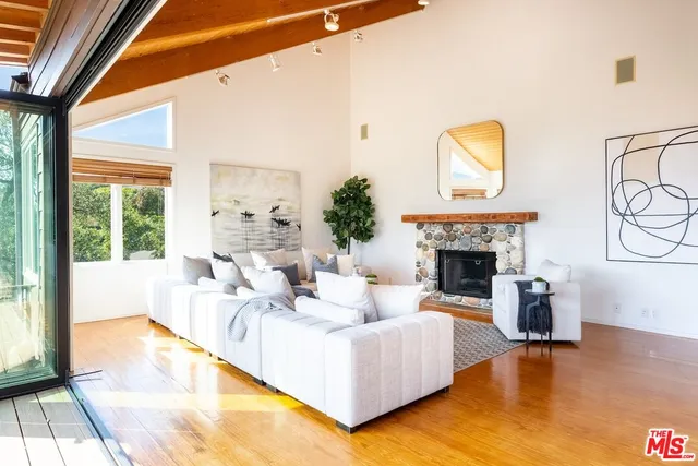 a living room with fireplace furniture and a large window