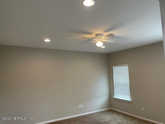 2218 Eagle Talon Circle Fleming Island, FL 32003 - Photo 34 of 40 an empty room with a chandelier fan and windows