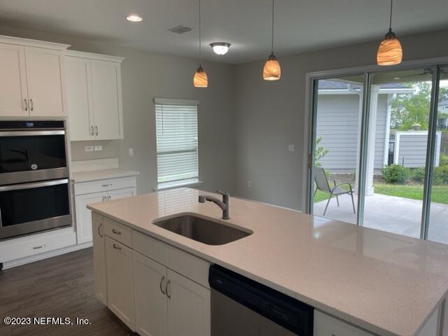 2218 Eagle Talon Circle Fleming Island, FL 32003 - Photo 9 of 40 a kitchen with stainless steel appliances granite countertop a sink a stove and a refrigerator