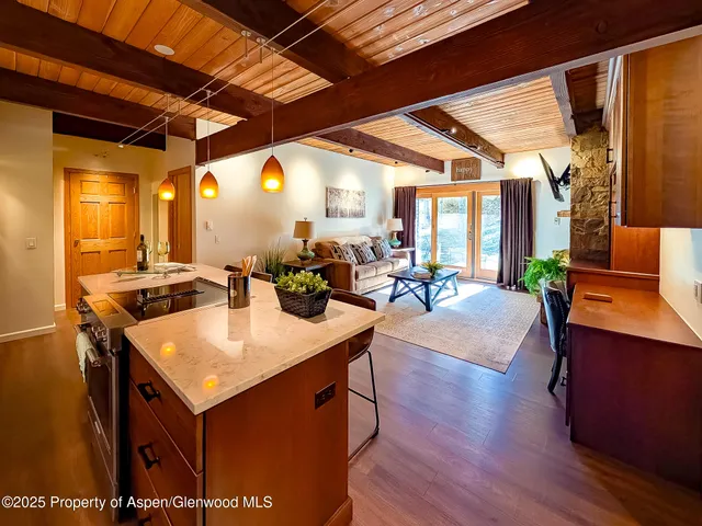 a view of a kitchen with kitchen island a sink and a table with chairs