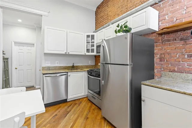 a kitchen with stainless steel appliances granite countertop a refrigerator and a stove