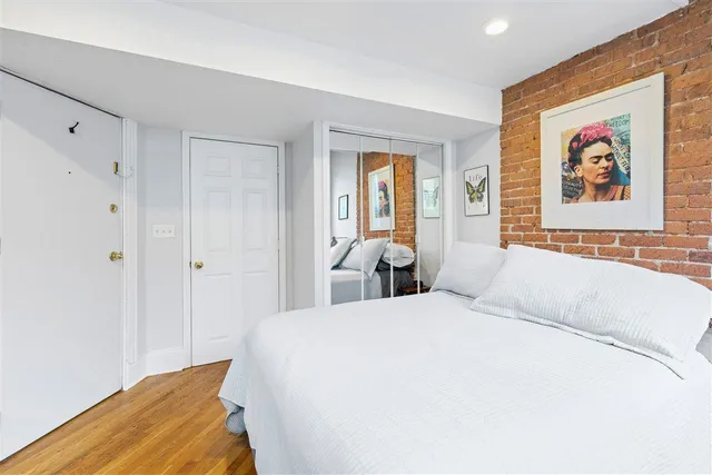 a bedroom with a bed and a painting on the wall